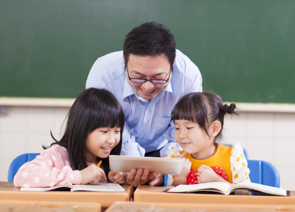 Teacher helping his students